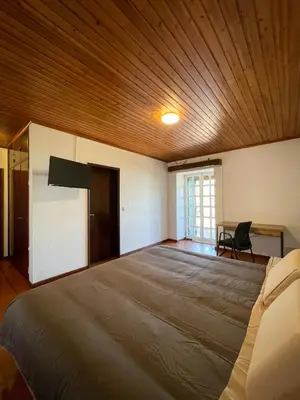 a bedroom with a large bed with a wooden ceiling at Estalagem Estrela in Estrela