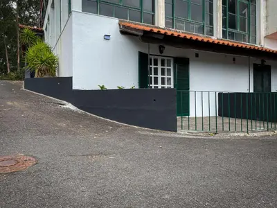 a white building with a green gate on a street at Estalagem Estrela in Estrela
