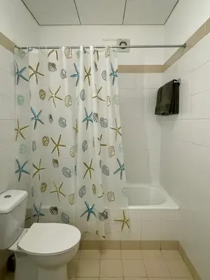 a bathroom with a toilet and a shower curtain with starfish at Estalagem Estrela in Estrela