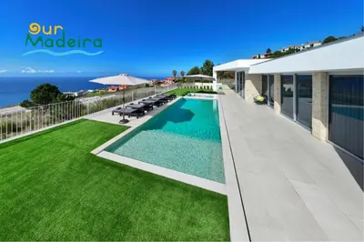 a villa with a swimming pool and a lawn at OurMadeira - Villa Adagio in Estreito da Calheta