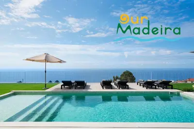 a swimming pool with chairs and an umbrella and the ocean at OurMadeira - Villa Adagio in Estreito da Calheta