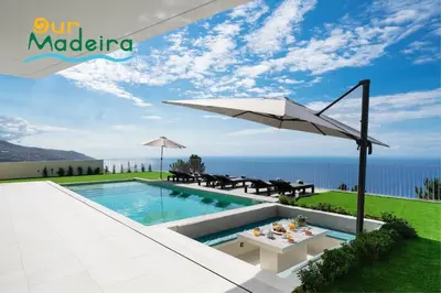 a villa with a swimming pool and a umbrella at OurMadeira - Villa Adagio in Estreito da Calheta