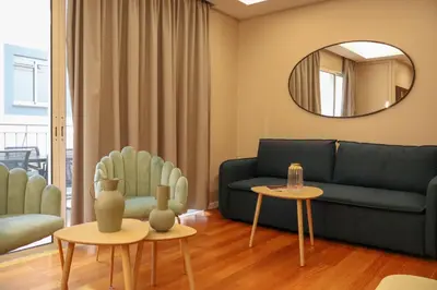 a living room with a couch and a mirror at Suites Do Carmo in Funchal