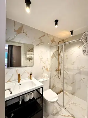 a bathroom with a sink and a toilet and a shower at Suites Do Carmo in Funchal