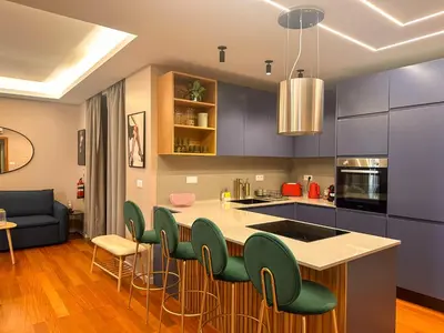 a kitchen with blue cabinets and green chairs at Suites Do Carmo in Funchal