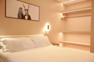 a bedroom with a white bed with a picture on the wall at Suites Do Carmo in Funchal