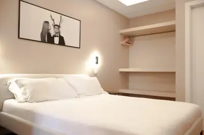a bedroom with a white bed with a picture on the wall at Suites Do Carmo in Funchal