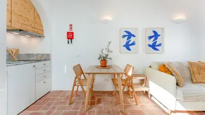 a kitchen and living room with a table and chairs at Stylish Slow Living 1 BDR House by LovelyStay in Vila do Bispo