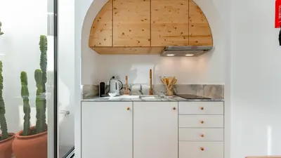a kitchen with white cabinets and a wooden ceiling at Stylish Slow Living 1 BDR House by LovelyStay in Vila do Bispo