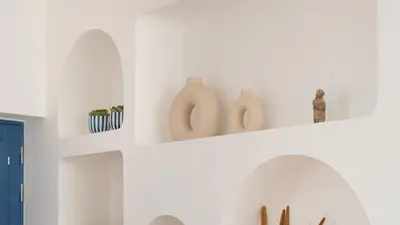 a white kitchen with white shelves with vases on them at Stylish Slow Living 1 BDR House by LovelyStay in Vila do Bispo