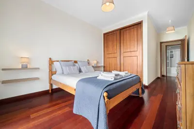a bedroom with a bed with a blue blanket on it at Casa Carlota by Atlântica in Santa Cruz