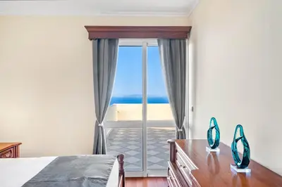 a bedroom with a large window with a view of the ocean at Casa Carlota by Atlântica in Santa Cruz
