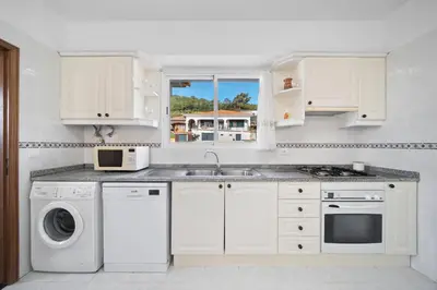 a white kitchen with a sink and a dishwasher at Casa Carlota by Atlântica in Santa Cruz
