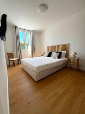 a bedroom with a white bed and a wooden floor at Casa da Porta Azul in Funchal