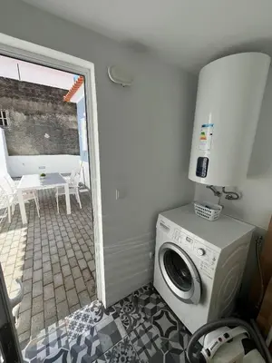 a laundry room with a washing machine and a patio at Casa da Porta Azul in Funchal