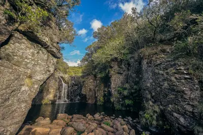 a waterfall in a canyon with rocks in the water at Casa da Porta Azul in Funchal