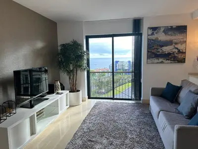a living room with a couch and a tv at Sunset Sea View in Funchal