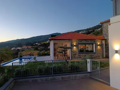a house with a balcony with a view at Vila Rouxinol in Arco da Calheta