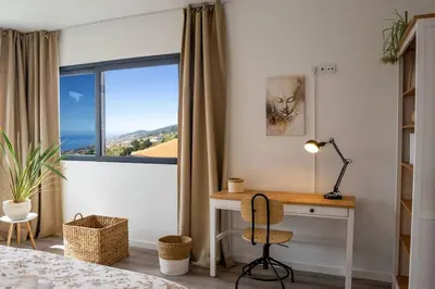 a bedroom with a desk and a window at Vila Rouxinol in Arco da Calheta