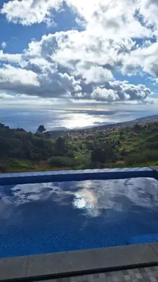 a swimming pool with a view of the water at Vila Rouxinol in Arco da Calheta