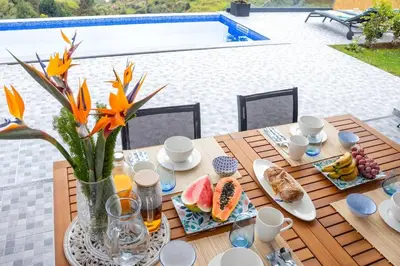 a wooden table with food on top of it with a table at Vila Rouxinol in Arco da Calheta