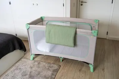 a pink crib with a green pillow in a bedroom at Casa Do Sol in Arco da Calheta