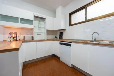 a kitchen with white cabinets and a sink and a window at Casa Do Sol in Arco da Calheta