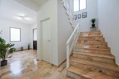 a hallway with a staircase in a home with wooden floors at Casa Do Sol in Arco da Calheta