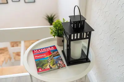 a table with a book and a lantern and a book at Casa Do Sol in Arco da Calheta