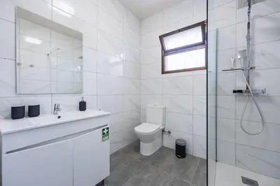 a bathroom with a toilet and a sink and a shower at Casa Do Sol in Arco da Calheta