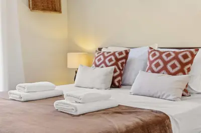 a bed with four pillows on it at Landure by Homie in São Vicente