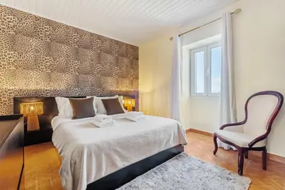 a bedroom with a large bed and a chair at Landure by Homie in São Vicente