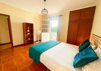 a bedroom with a large bed with green pillows on it at Villa Nunes in Funchal