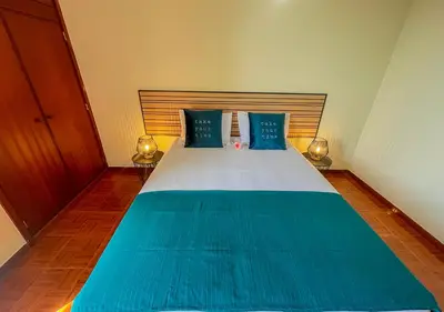 a bedroom with a blue and white bed with two lamps at Villa Nunes in Funchal