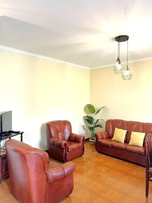 a living room with two leather chairs and a couch at Villa Nunes in Funchal