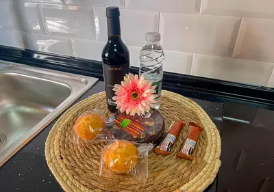 a bottle of wine and a flower on a basket at Villa Nunes in Funchal