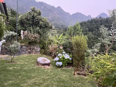 a garden with a bench and flowers in the grass at Mountain Retreat - ZemBica by Atlantic Holiday in São Vicente