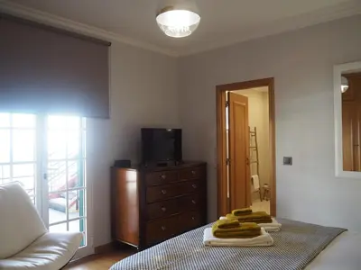 a living room with a couch and a dresser with towels at Camacho Residence in Funchal