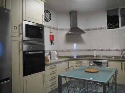 a kitchen with a table and a clock on the wall at Camacho Residence in Funchal
