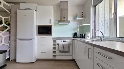 a white kitchen with a refrigerator and a sink at Pino's Getaway by LovelyStay in Funchal