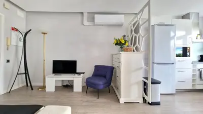 a kitchen with a blue chair and a desk and a refrigerator at Pino's Getaway by LovelyStay in Funchal
