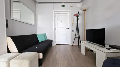 a living room with a black couch and a television at Pino's Getaway by LovelyStay in Funchal