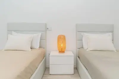 a bedroom with two beds and a lamp on a nightstand at Oak Tree Ocean View in Ponta do Sol