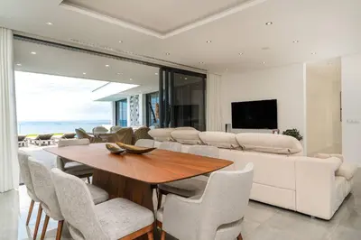 a dining room with a table and a couch at Oak Tree Ocean View in Ponta do Sol