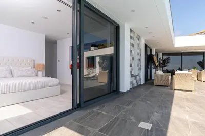 a living room with a bed and a glass door at Oak Tree Ocean View in Ponta do Sol