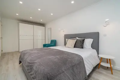 a bedroom with a large bed and a blue chair at Tranquilidade, Quiet Apartament in Funchal City Center in Funchal
