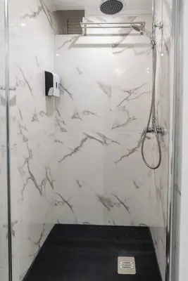 a bathroom with a shower with white marble walls at Tranquilidade, Quiet Apartament in Funchal City Center in Funchal