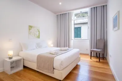 a white bedroom with a bed and a window at GuestReady - Relaxing Retreat in Madeira in Machico