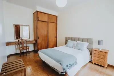 a bedroom with a bed and a wooden cabinet at Casa Branca Apartments by Wanderlust Madeira, vacation rentals in Funchal