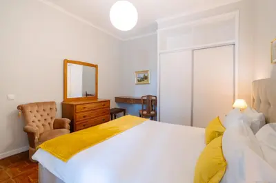 a bedroom with a bed and a mirror and a chair at Casa Branca Apartments by Wanderlust Madeira, vacation rentals in Funchal